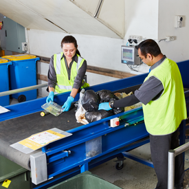 Two consolidated employees sorting rubish on a conveyor belt